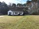 Well-manicured lawn surrounds this one-story home with classic white siding and ample front yard space at 212 Davis Farm Dr, Selma, NC 27576