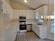 Functional kitchen featuring white cabinetry and modern appliances, and wood-look flooring at 212 Davis Farm Dr, Selma, NC 27576