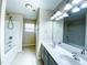 Bright bathroom with double vanity, tub-shower combo and modern lighting at 212 Liberty Rose Dr, Morrisville, NC 27560