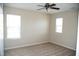 Bright bedroom with plush carpet, two windows, and a ceiling fan at 212 Liberty Rose Dr, Morrisville, NC 27560