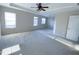 Spacious bedroom with neutral walls, plush carpet, tray ceiling, and natural light at 212 Liberty Rose Dr, Morrisville, NC 27560