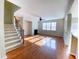 Light-filled living room with hardwood floors, fireplace, and stairs at 212 Liberty Rose Dr, Morrisville, NC 27560