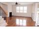 Cozy living room featuring hardwood floors, a fireplace, and a ceiling fan at 212 Liberty Rose Dr, Morrisville, NC 27560