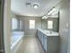 Well-lit main bathroom featuring double sink vanity, soaking tub, and glass enclosed shower at 212 Liberty Rose Dr, Morrisville, NC 27560