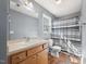 Neutral bathroom with gray walls, wooden vanity, large mirror, and shower-tub combo at 220 Courtland Dr, Angier, NC 27501