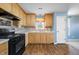 Bright kitchen featuring wood cabinets, light countertops, tile backsplash, and stainless steel appliances at 220 Courtland Dr, Angier, NC 27501