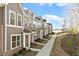 Street view of new townhomes featuring varied siding colors, brick accents, and well-maintained landscaping at 223 Frosted Iris Lane Ln # 176, Garner, NC 27529