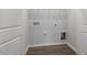 The laundry room has wood floors, white walls, and the hookups for a washer and dryer at 223 Frosted Iris Lane Ln # 176, Garner, NC 27529