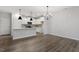 Open-concept living and dining area with hardwood floors and modern light fixtures at 223 Frosted Iris Lane Ln # 176, Garner, NC 27529