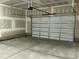 Large two-car garage showcasing a concrete floor, access door, and an automatic garage door at 2242 Eldridge Rd, Newton Grove, NC 28366