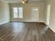 Spacious living room with dark wood floors, a ceiling fan, a large window, and neutral-colored walls at 2242 Eldridge Rd, Newton Grove, NC 28366