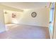 Bright living room with neutral carpet, large window, decorative clock and a view into the adjacent dining area at 2513 Boothbay Ct, Raleigh, NC 27613
