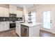 Bright kitchen features white cabinets, stainless steel appliances, and a center island with seating and granite countertops at 275 Deodora Ln, Cameron, NC 28326