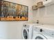 Efficient laundry room with modern washer/dryer units and decorative wall art at 275 Deodora Ln, Cameron, NC 28326