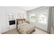 Bright bedroom features two large windows, a tan quilt bed and a partial bathroom view at 301 Beacon Dr, Pittsboro, NC 27312