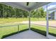 An enclosed screened porch with a view of the green backyard and the forest at 301 Beacon Dr, Pittsboro, NC 27312