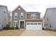 Charming two-story home with a stone accent wall, blue shutters, and a well-maintained front yard at 311 Silverhawk Ln, Durham, NC 27703