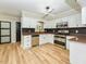 Modern kitchen featuring white cabinets, stainless steel appliances, dark backsplash, and light wood flooring at 314 Mill Creek Dr, Fuquay Varina, NC 27526