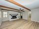 Cozy living room with white brick fireplace, wood beam ceiling, and wood floors at 314 Mill Creek Dr, Fuquay Varina, NC 27526