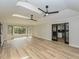 Open living area with light wood floors, bright windows, and black framed glass doors to the kitchen at 314 Mill Creek Dr, Fuquay Varina, NC 27526