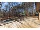 Spacious wooden backyard deck with wooden railing overlooking the in-ground pool and wooded area at 3217 Stoneyford Ct, Raleigh, NC 27603