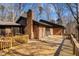 Expansive brick home with a wooden deck, brick chimney, and mature trees at 3217 Stoneyford Ct, Raleigh, NC 27603