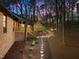 Exterior twilight view of a brick house with a stone walkway leading to a serene backyard at 3217 Stoneyford Ct, Raleigh, NC 27603