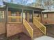 Inviting brick house with a covered front porch, wooden railings, and freshly landscaped yard at 3217 Stoneyford Ct, Raleigh, NC 27603