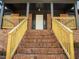 Charming front entrance with brick steps, wooden railing, and covered porch at 3217 Stoneyford Ct, Raleigh, NC 27603