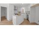 Modern white kitchen featuring stainless steel appliances, an island, and hardwood floors at 3217 Stoneyford Ct, Raleigh, NC 27603