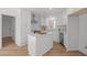 Modern white kitchen features an island, stainless steel appliances, and new hardwood floors at 3217 Stoneyford Ct, Raleigh, NC 27603