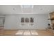 Spacious living room with hardwood floors, a skylight, a stone fireplace, and backyard views at 3217 Stoneyford Ct, Raleigh, NC 27603