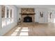 Bright living room with stone fireplace, wood mantel, and large windows providing ample natural light at 3217 Stoneyford Ct, Raleigh, NC 27603