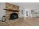 Open-concept living room featuring a stone fireplace and seamless flow into a modern kitchen at 3217 Stoneyford Ct, Raleigh, NC 27603