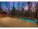 Expansive wooden deck overlooks a sparkling in-ground pool surrounded by a lush, wooded landscape at 3217 Stoneyford Ct, Raleigh, NC 27603