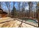 Expansive wooden deck overlooks a sparkling in-ground pool surrounded by a lush, wooded landscape at 3217 Stoneyford Ct, Raleigh, NC 27603