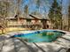 In-ground pool surrounded by a concrete patio and featuring a brick house and wooden deck in the background at 3217 Stoneyford Ct, Raleigh, NC 27603