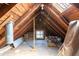 Unfinished attic space with exposed wooden beams and a window, offering potential for customization at 347 W Trade St, Burlington, NC 27217