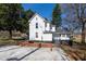 View of back of the two-story home with a small porch and ample backyard space at 347 W Trade St, Burlington, NC 27217