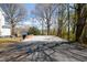 A backyard with parking, a brick wall, and large trees at 347 W Trade St, Burlington, NC 27217