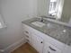 A bright bathroom featuring a modern granite countertop vanity and large mirror at 347 W Trade St, Burlington, NC 27217