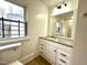 A well-lit bathroom featuring a vanity, toilet, and a large mirror for a functional space at 347 W Trade St, Burlington, NC 27217