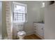 Clean bathroom with a toilet, shower-tub combination, vanity with granite countertops, and a window at 347 W Trade St, Burlington, NC 27217