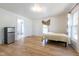 Bedroom featuring a bed, 3 windows, a mini refrigerator, and light hardwood floors at 347 W Trade St, Burlington, NC 27217