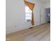Bright bedroom with light hardwood floors, white walls, a large window, and white trim at 347 W Trade St, Burlington, NC 27217