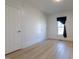 Bedroom featuring two doors, light hardwood floors, white walls, and a window at 347 W Trade St, Burlington, NC 27217