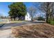 This is a house with a spacious driveway and a well-maintained lawn, framed by mature trees and a clear blue sky at 347 W Trade St, Burlington, NC 27217