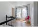 Bright hallway with hardwood floors and natural light showcases a cozy reading nook by the window at 347 W Trade St, Burlington, NC 27217