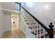 Hallway with staircase and recently refinished wood floors creates an open and bright entry space at 347 W Trade St, Burlington, NC 27217