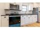 Updated kitchen features stainless steel appliances, white cabinetry, and backsplash at 347 W Trade St, Burlington, NC 27217